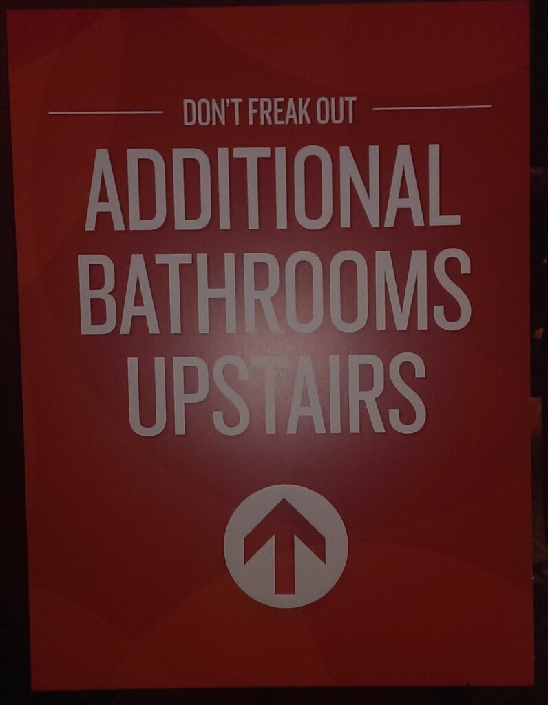 Sign reading "Don't Freak Out - Additional Bathrooms Upstairs"