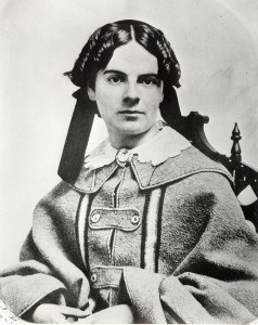  Black and white photograph of a woman in 19th century clothing. 