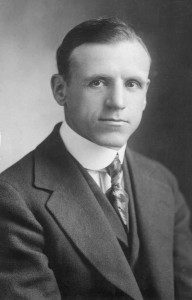  Black and white photograph of a man in a suit. 