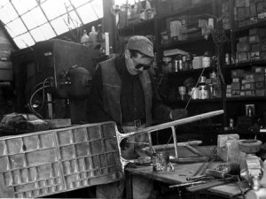  Black and white photograph of a sculptor welding. 