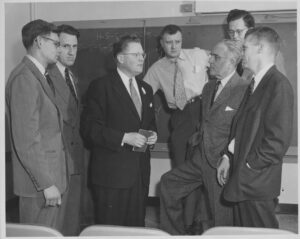 Dr. Marvin Carmack (third from left) talks with other chemists after delivering a lecture at du Pont Laboratories (1952).