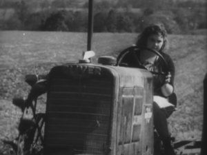 Girl of 12 driving tractor, still from Farmer At War