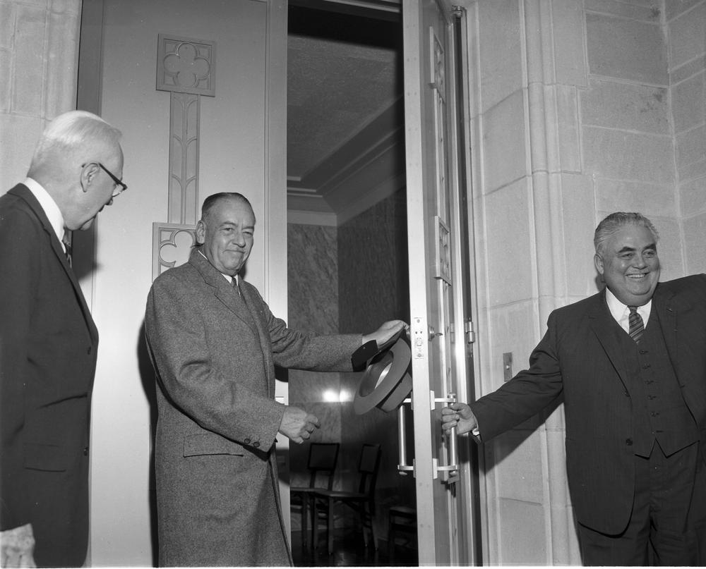 Black and white image of Herman B Wells holding the door to Lilly Library as J.K. Lilly enters.