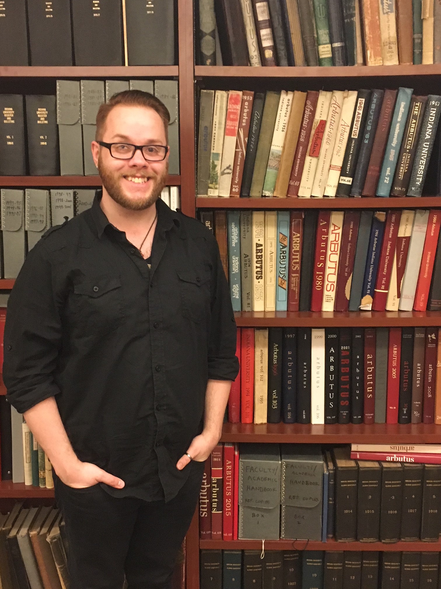 Photograph of IU Archives graduate student Walker Byer in front of bookcase