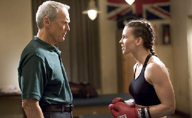 Image from the film Million Dollar Baby showing a woman boxer talking to her male coach.