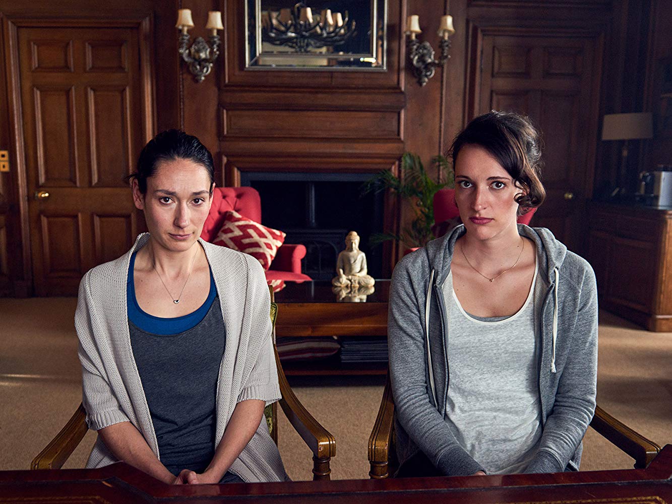 Two women sit in a chair from the TV series, Fleabag
