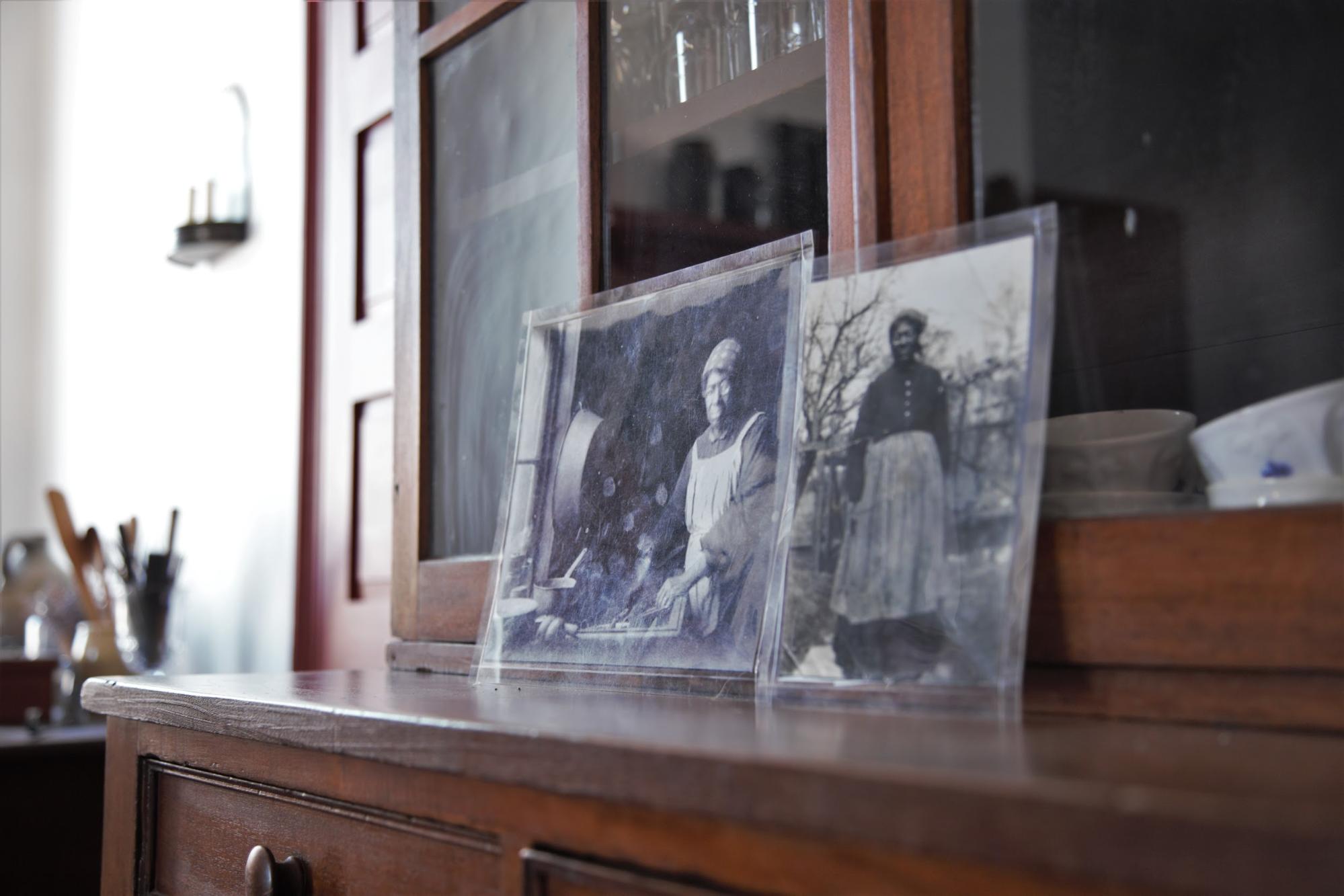 historic black and white pictures sitting on a china cabinet depicting African American woman