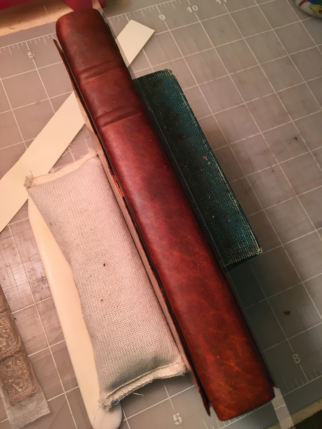 The new leather has beene pasted onto the book and is darkened from all the moisture.