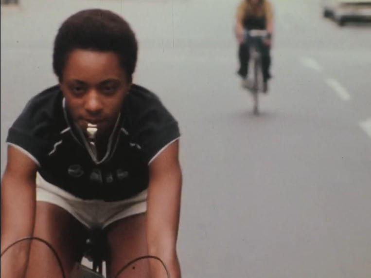 Image of woman on a bike blowing a whistle from the film, Born in Flames