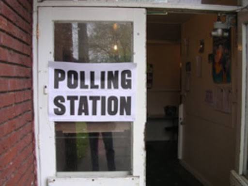 Image of signage on a door that reads, "Polling Station," from the documentary, Voting a Right and Responsibility