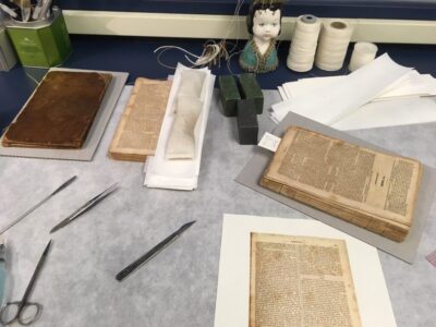 A book on a conservator's bench, in the process of being repaired.