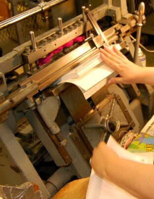 A book being sewn on an oversewing machine