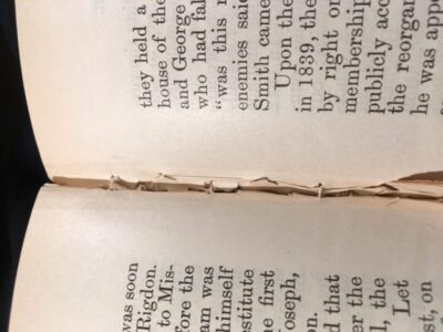 Closeup of the inner margin of a book that was oversewn showing the clumpy irregular stitches.