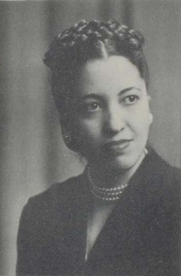 Black and white headshot of Mildred Clift with braids and wearing pearls