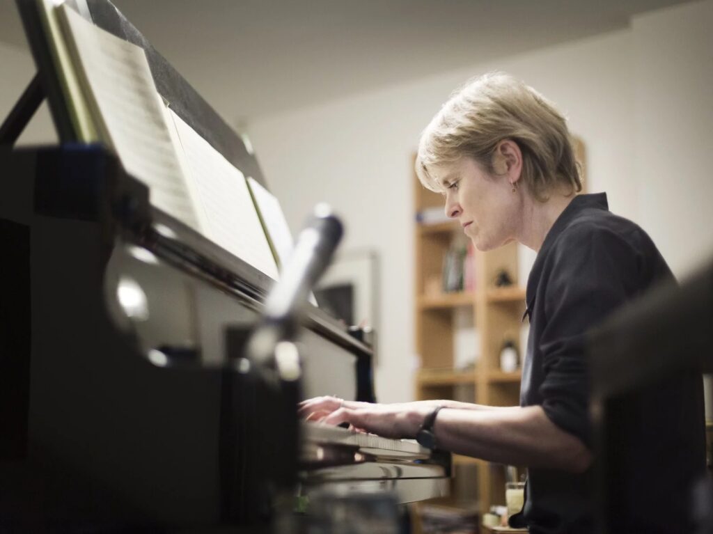 Photograph of composer Rachel Portman playing a piano.