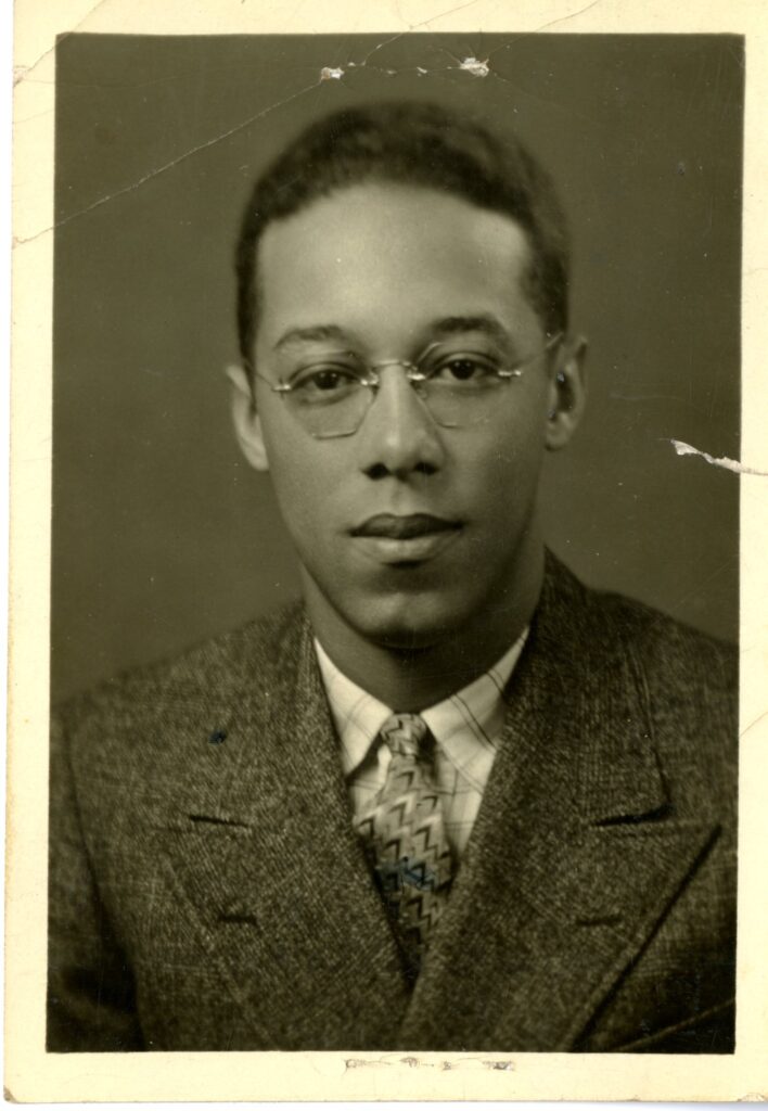 Black and white headshot of Wilbert Miller wearing a suit and tie