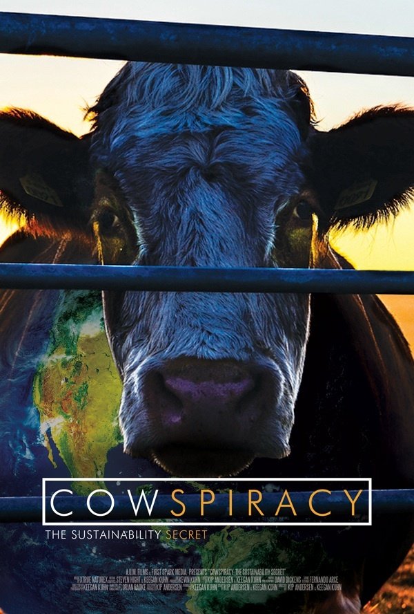 A movie poster for the documentary "Cowspiracy", depicting a lone cow at dawn watching through the bars of a cate, one half of her body overlaid with an image of the planet.