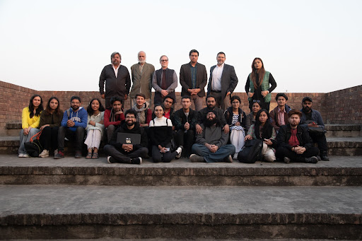 Richard K. Wolf and Alan Burdette posing for a group portrait with faculty and students at the National College of Arts in Lahore, Pakistan.