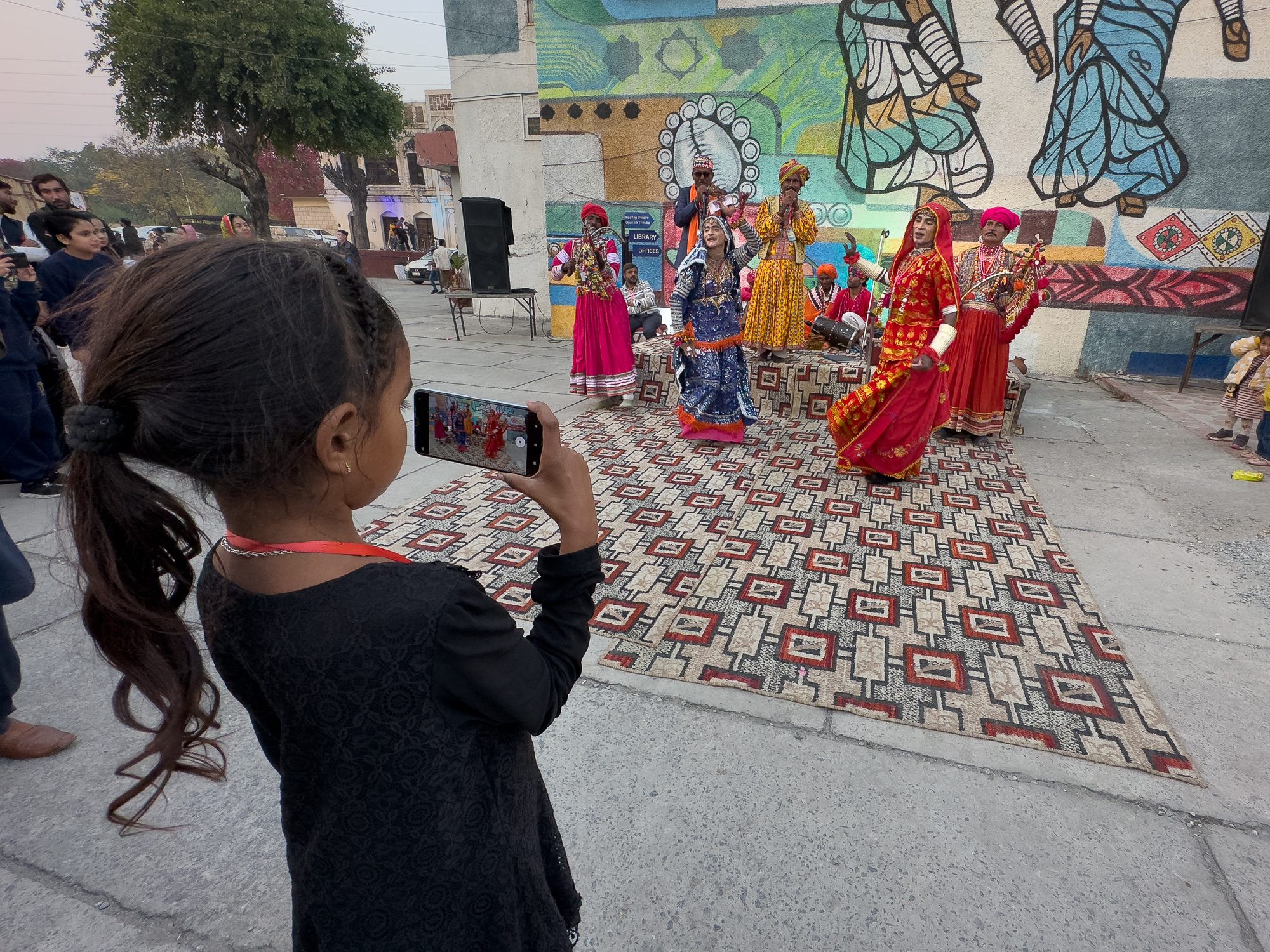 Young Pakistani girl using a phone to make a video of dancers and musicians from the Sindh region at the Lok Mela Festival in Islamabad, Pakistan.