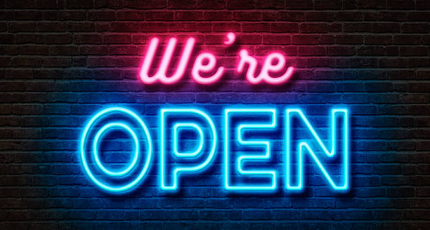 Photograph of a neon sign reading "We're Open" in pink and blue.