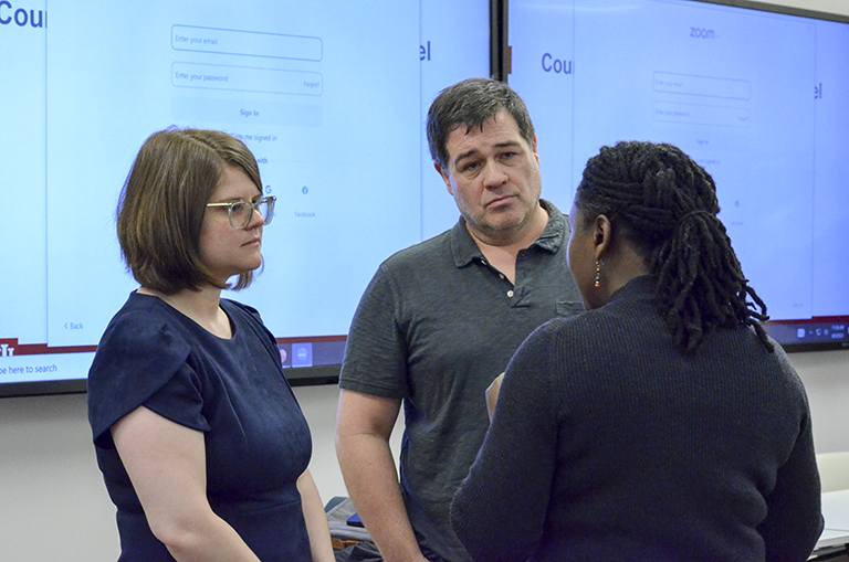 Sarah Hare (left) and Greg Carter (middle) speaking to an attendee during a beak.