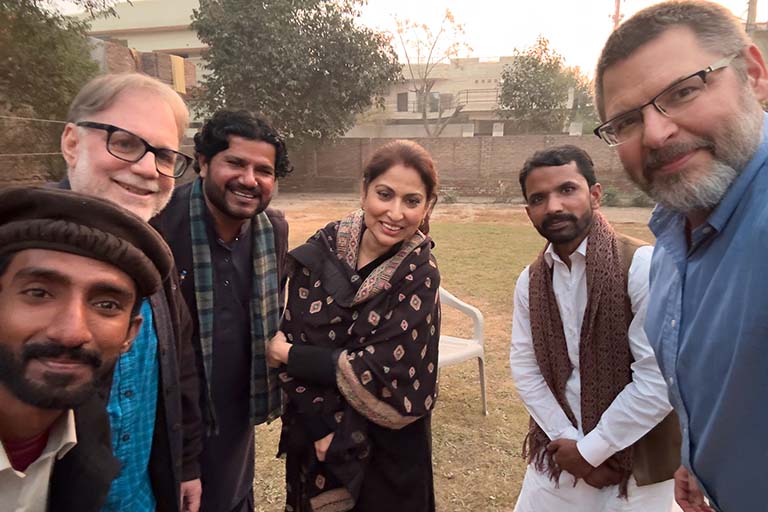 Richard K. Wolf and Alan Burdette standing outdoors with musicians Azhar Ali, Atta Hussain Multani, Rahat Bano Multanikar, and an unidentified naqqara player in Multan, Pakistan.