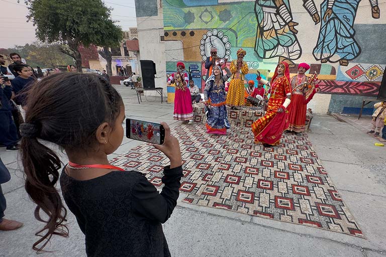 Young Pakistani girl using a phone to make a video of dancers and musicians from the Sindh region at the Lok Mela Festival in Islamabad, Pakistan.