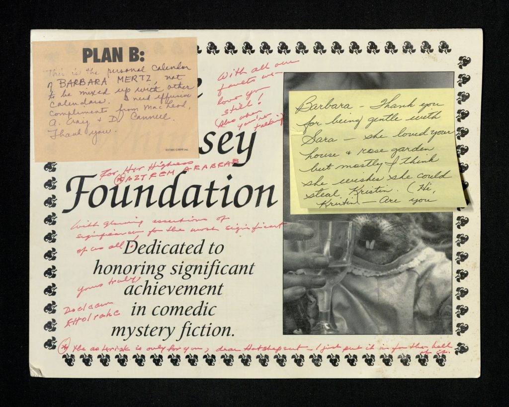 Calendar cover that reads “The Whimsey Foundation // Dedicated to honoring significant achievement in comedic mystery fiction” next to a black-and-white photo of a woman holding a glass in front of a taxidermied muskrat in a hat and dress. A yellow post-it note obscures the top half of the photo and has the following handwritten text: “Barbara - Thank you for being gentle with Sara – she loved your house and rose garden but mostly I think she wishes she could steal Kristin. (Hi, Kristin – Are you”. An orange post-it note labeled “Plan B” in the top left corner has the following handwritten text: “This is the personal calendar of BARBARA MERTZ, not to be mixed up with other calendars. I need effusive compliments from MacLeod, A. Craig and D. Cannell. Thank you.” Written in red pen in the spaces between printed text on the cover is the following text: “With all our fault we love you still! (Also when you’re talking) // For Her Highness *Aztrem Arabrab *the asterisk is only for you, dear Hatshepsut – I just put it in for the hell of it // With glowing assertions of significance for the most significant of us all! Yours truly, Doelcam Eltolrahc”.