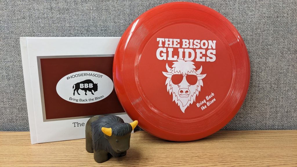 Memorabilia from the Bring Back the Bison campaign including a frisbee, toy and book