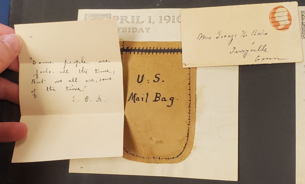 Square note with printed date April 1, 1910, Friday. Pouch on note with “U.S. Mail Bag” written on it. Top right corner has mini envelope addressed to “Mrs. George H. Bates Terryville, Conn” with small red stamp in top right corner. Left side has mini letter: “Some people are fools all the time, But we all are, some of the time.” S. P. A. 